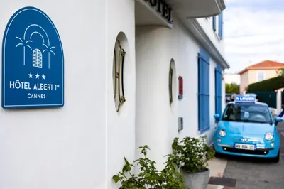 a blue sign on the side of a building with a car at Hotel Albert 1er in Cannes