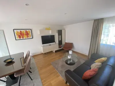 a living room with a couch and a television at Riviera Eden Palace in Cannes
