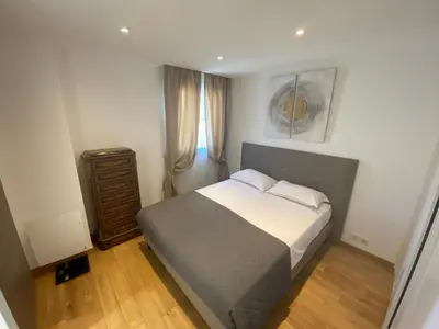 a small bedroom with a bed and a dresser at Riviera Eden Palace in Cannes