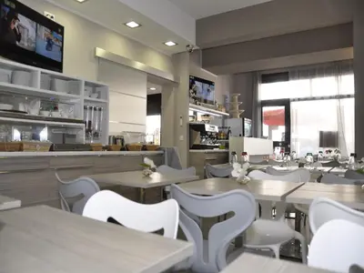 a restaurant with white tables and white chairs at Riviera Eden Palace in Cannes