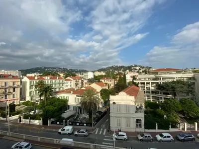 a city with cars parked on a street with buildings at Riviera Eden Palace in Cannes