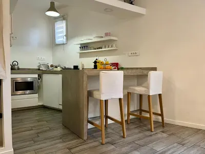 a kitchen with a counter and two white chairs at Appartement Le Suquet proche Croisette in Cannes