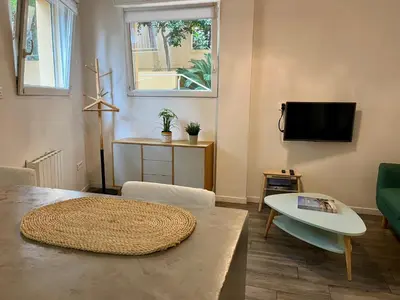 a living room with a table and a tv at Appartement Le Suquet proche Croisette in Cannes