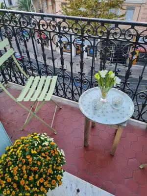 a table and chairs and flowers on a balcony at Chez Grace in Cannes