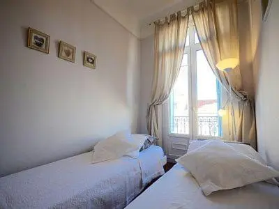 a bedroom with two beds and a window at Chez Grace in Cannes