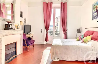 a living room with a bed and a fireplace at Chez Grace in Cannes