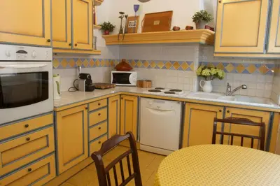 a kitchen with yellow cabinets and a table and chairs at Chez Grace in Cannes