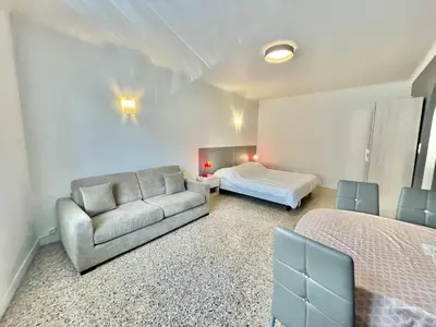 a bedroom with a couch and a bed in a room at Themis by Welcome to Cannes in Cannes