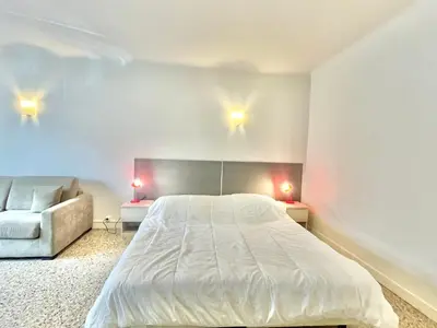 a bedroom with a large bed and a couch at Themis by Welcome to Cannes in Cannes