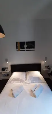 a bed with white sheets and two towels on it at Cannes Riviera in Cannes