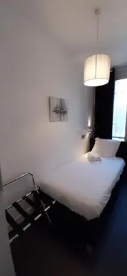a bedroom with a large white bed and a lamp at Cannes Riviera in Cannes
