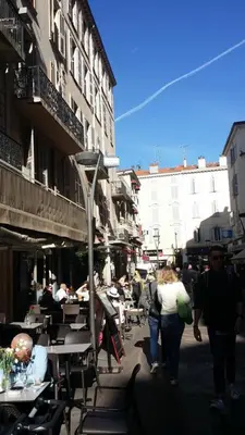 a group of people walking down a street with tables and chairs at Cannes Riviera in Cannes