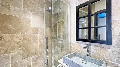 a bathroom with a sink and a glass shower at Hotel Le Florian in Cannes