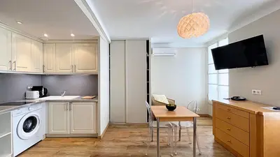 a kitchen with a washer and dryer and a table at Hotel Le Florian in Cannes