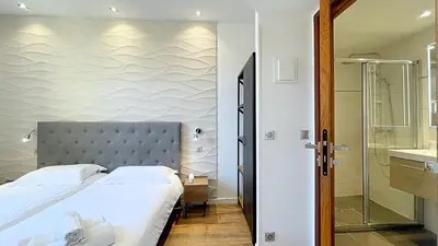 a bedroom with a large bed and a shower at Hotel Le Florian in Cannes
