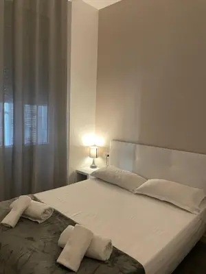 a white bedroom with a large bed with two pillows at Hôtel Anna Livia in Cannes