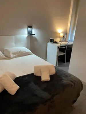 a bedroom with a bed with two towels on it at Hôtel Anna Livia in Cannes