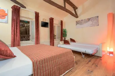 a bedroom with two beds and a bench in it at Charming house in Cannes