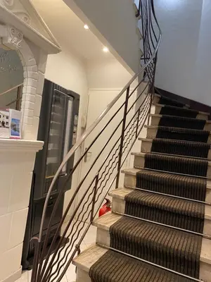 a staircase in a home with a wrought iron railing at Hotel Lutetia in Cannes
