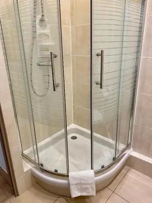 a shower with a glass shower stall in a bathroom at Hotel Lutetia in Cannes