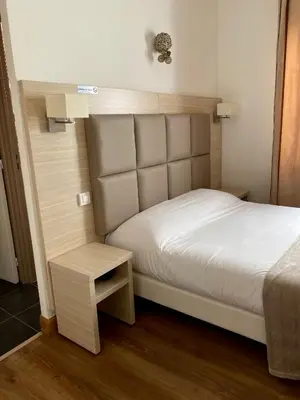 a small bedroom with a bed and a table at Hotel Lutetia in Cannes