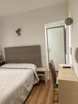 a bedroom with a bed and a table and a mirror at Hotel Lutetia in Cannes