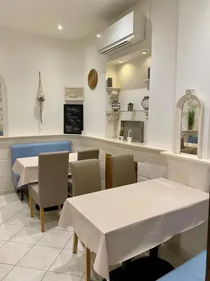 a restaurant with tables and chairs and a counter at Hotel Lutetia in Cannes