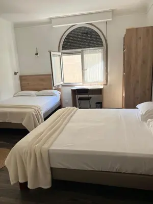 a hotel room with two beds and a window at Hotel Lutetia in Cannes