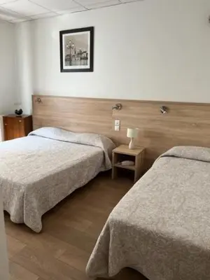a hotel room with two beds and a picture on the wall at Hotel Lutetia in Cannes