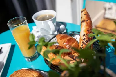a plate of food with bread and a glass of orange juice at Hotel Amiraute in Cannes
