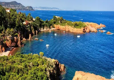a cove in the ocean with boats in the water at Hotel Amiraute in Cannes