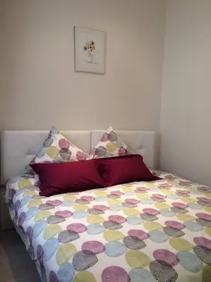 a bed with a colorful comforter and two pillows at Palme d'hote in Cannes
