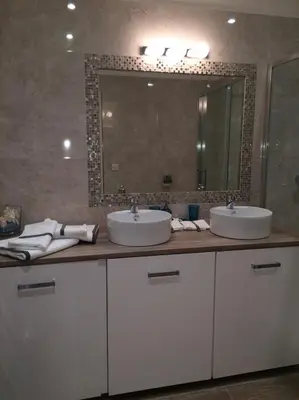 a bathroom with two sinks and a large mirror at Palme d'hote in Cannes