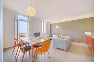 a living room with a table and chairs and a couch at IMMOGROOM - SEA View on the Port - Next to the beaches - AC - Wifi in Cannes