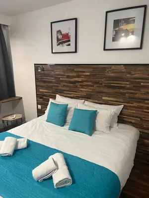 a large bed with blue and white pillows on it at Resothel Group in Le Cannet