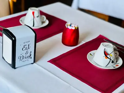 a table with two plates and a box with a cat of a drink at Resothel Group in Le Cannet