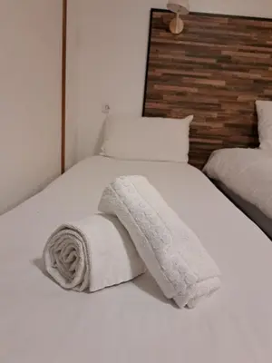 a white bed with two towels on it at Resothel Group in Le Cannet