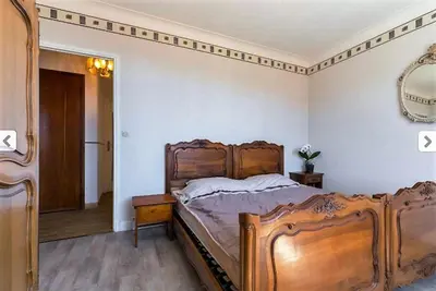 a bedroom with a large wooden bed and a mirror at Villa Lerina in Cannes