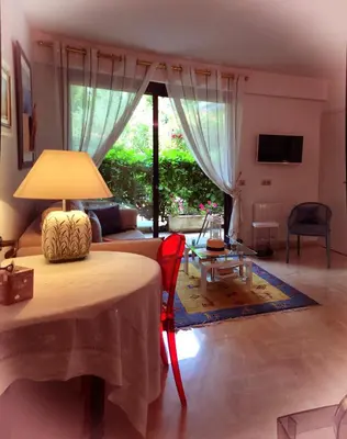 a living room with a table with a lamp on it at Un Coin de Paradis in Cannes