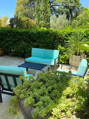 a patio with two chairs and a blue couch at Un Coin de Paradis in Cannes