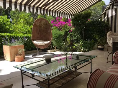 a patio with a glass coffee table and a chair at Un Coin de Paradis in Cannes
