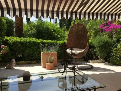a patio with a table and a chair and a pool at Un Coin de Paradis in Cannes