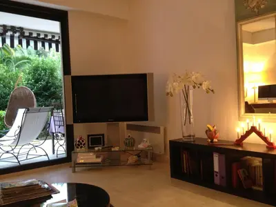 a living room with a flat screen tv on the wall at Un Coin de Paradis in Cannes