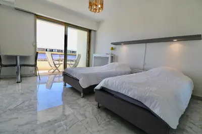 a bedroom with two beds and a flat screen tv at 2 bedroom & studio Palais Royal 2 mins from Croisette and Carlton in Cannes
