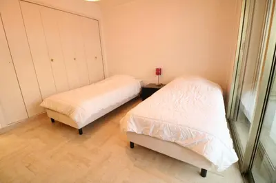 a bedroom with two beds and a window at 2 bedroom & studio Palais Royal 2 mins from Croisette and Carlton in Cannes