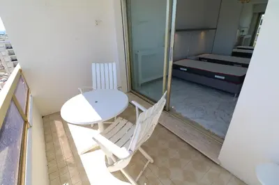 a room with a table and two chairs and a bed at 2 bedroom & studio Palais Royal 2 mins from Croisette and Carlton in Cannes