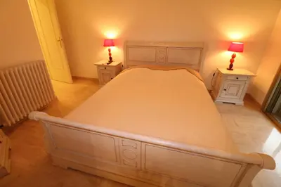 a bedroom with a large bed with two night stands at 2 bedroom & studio Palais Royal 2 mins from Croisette and Carlton in Cannes