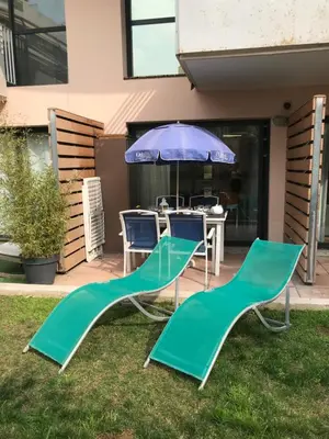 two chairs and a table with an umbrella at SOPHIES HOMES FÉLIBRIGES BEACH & PALAIS des FESTIVALS in Cannes