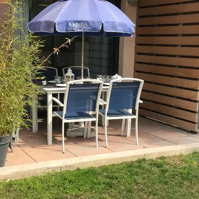 a table and chairs under an umbrella on a patio at SOPHIES HOMES FÉLIBRIGES BEACH & PALAIS des FESTIVALS in Cannes