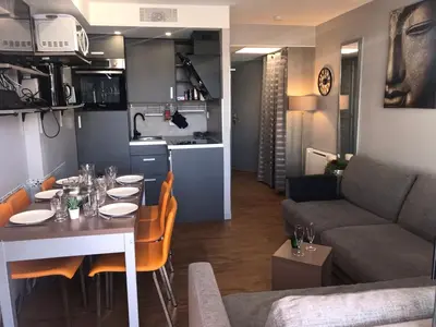 a kitchen and a living room with a table and a couch at SOPHIES HOMES FÉLIBRIGES BEACH & PALAIS des FESTIVALS in Cannes